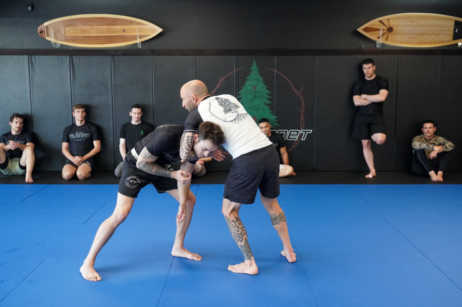 Instructor demonstrating a takedown while students watch